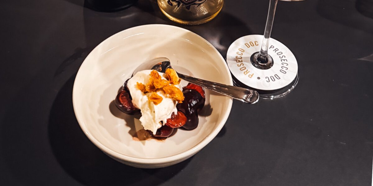 Schmand-Eis mit Schwamm-Toffee und Kirschen mit Prosecco DOC.