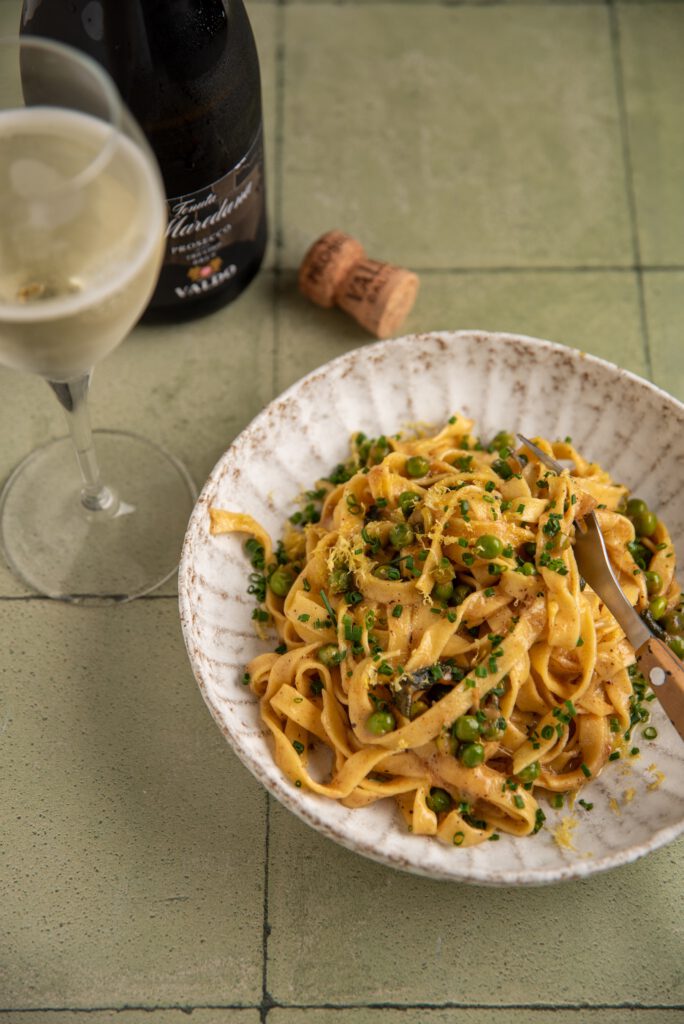 Tagliatelle mit Zitronenbutter, süßen Erbsen und Salbei, dazu ein Prosecco DOC Brut.